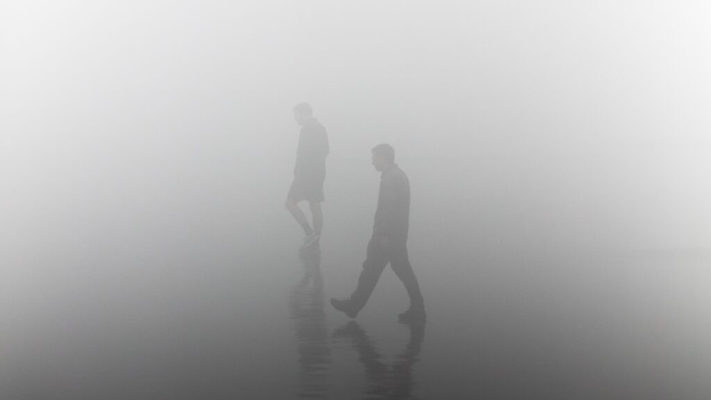 People walking through dense fog