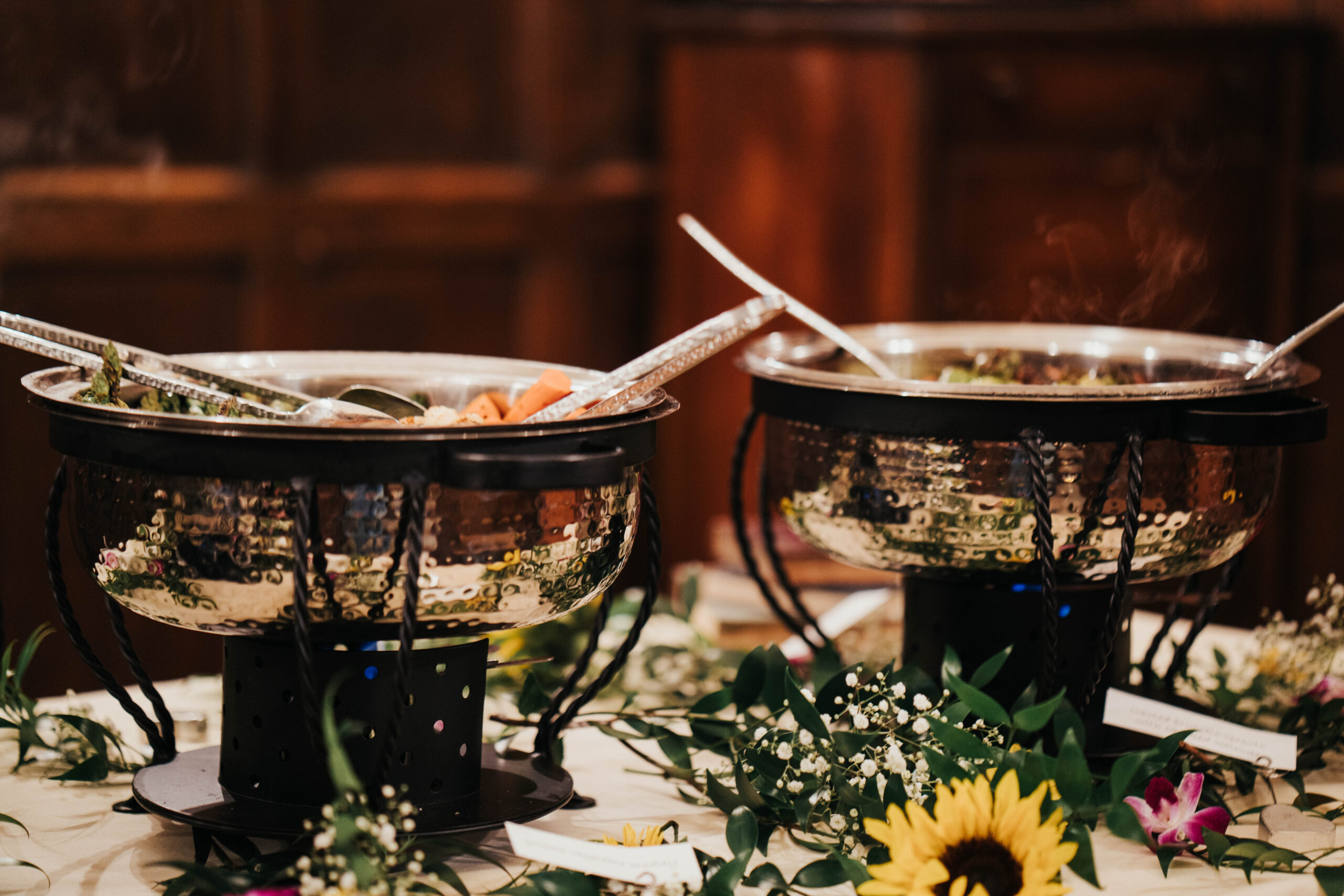 Buffet line with hot food, decorated with flowers