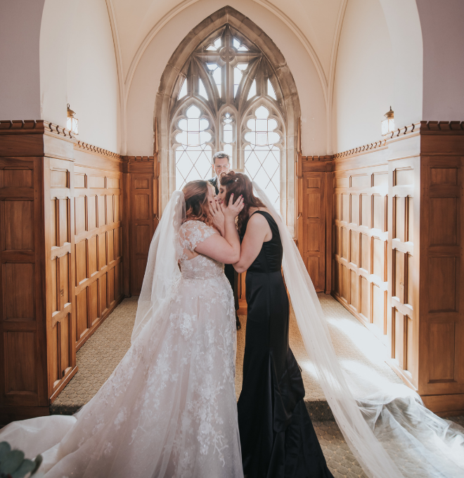 Two brides kissing in Skinner Chapel