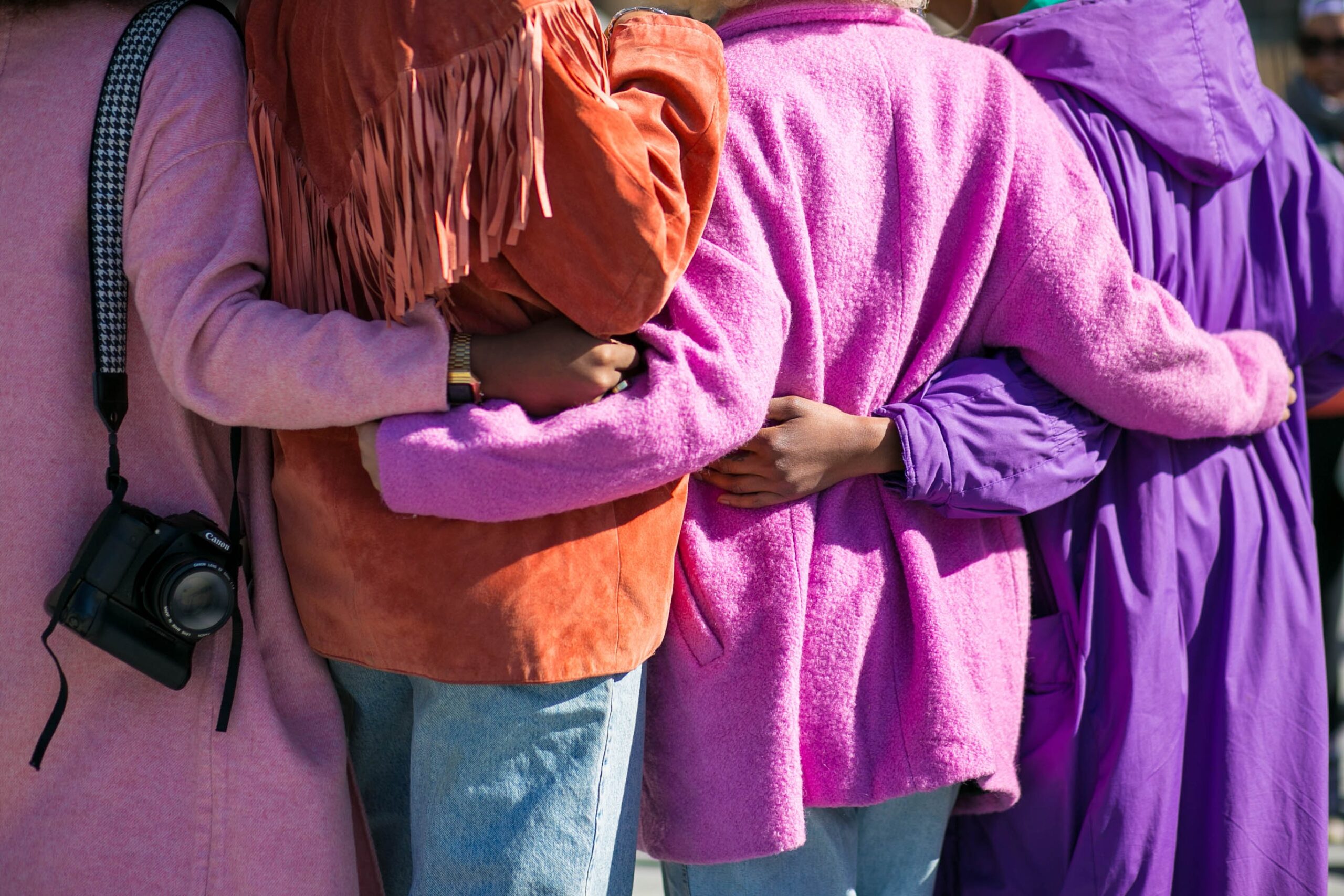 Diverse group of women standing with their arms around each other